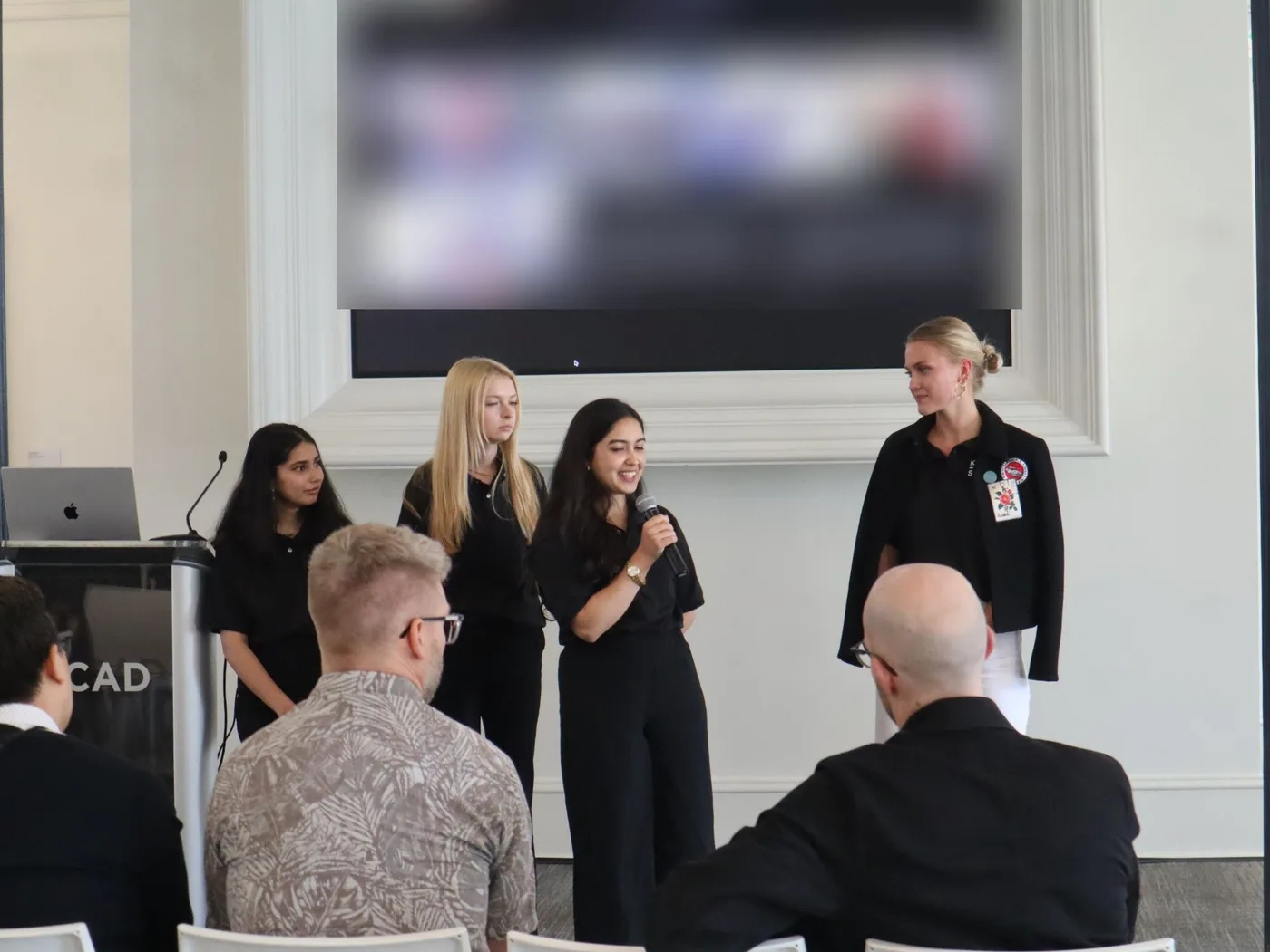 Navyaa presenting her team’s work to a panel, microphone in hand.